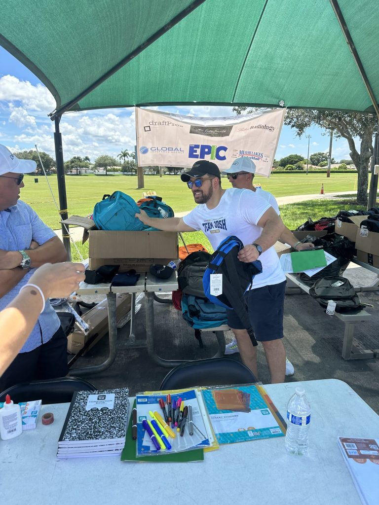 Josh Distributing backpacks for a Back-to-School event.